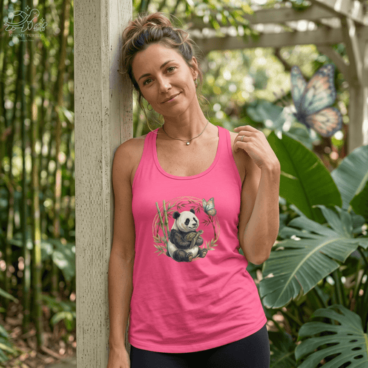 Woman wearing a pink Panda and turtle racerback tank beside bamboo with butterfly detail.