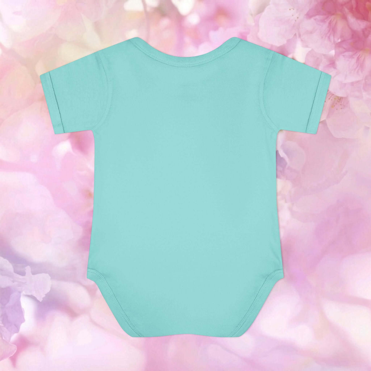 Plain back of the aqua Harvest Friends Infant Bodysuit displayed against a soft pink floral background.