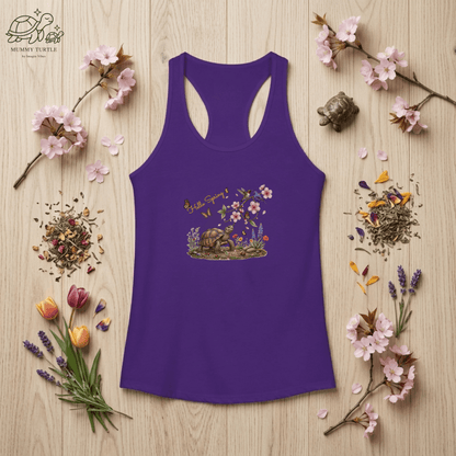 Women’s spring racerback tank flat lay in purple with Hello Spring print, styled with flowers and soft spring decor.