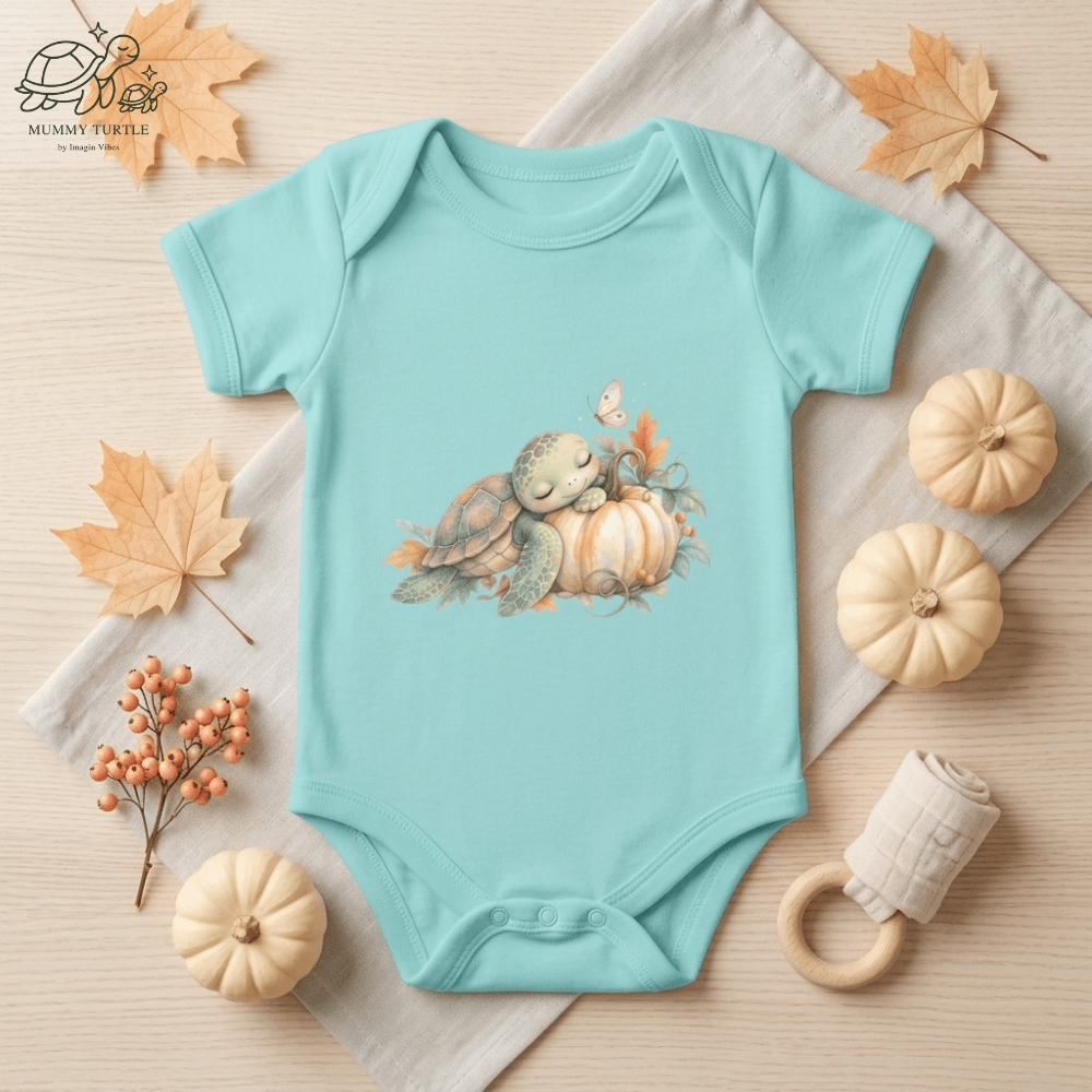 Aqua Harvest Friends Infant Bodysuit styled in a warm fall flat lay featuring the turtle and turkey harvest friendship artwork.