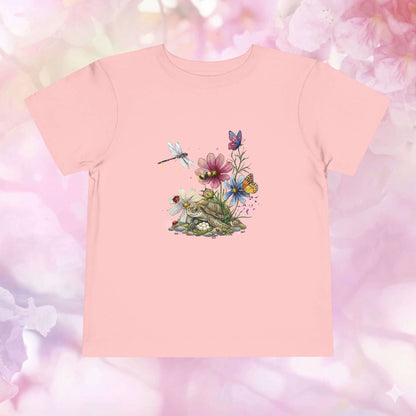 Toddler flower shirt featuring a tiny turtle, vibrant wildflowers, butterflies, and a dragonfly against a pink background.