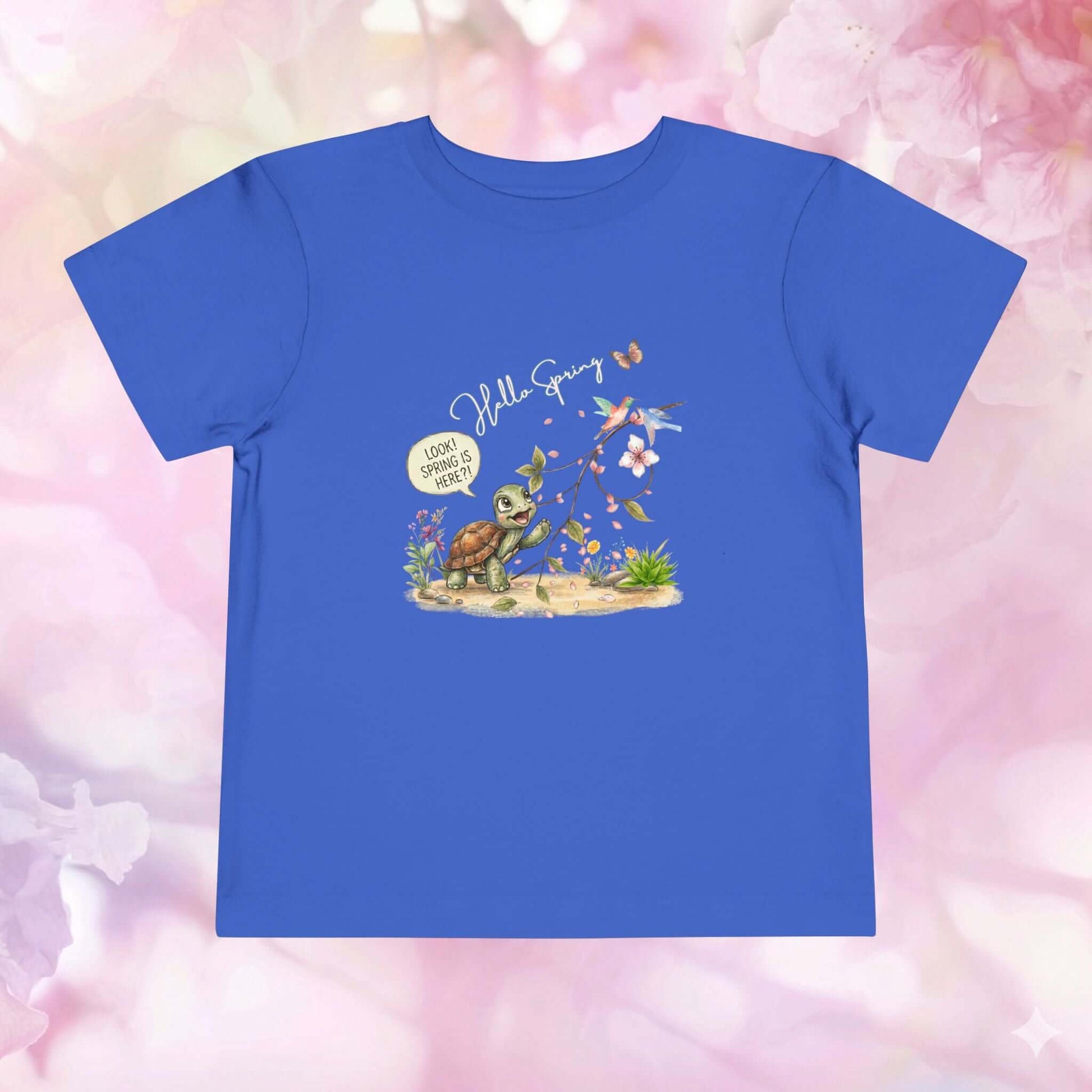 Toddler spring shirt featuring a cheerful turtle discovering flowers and butterflies with a light blue background.