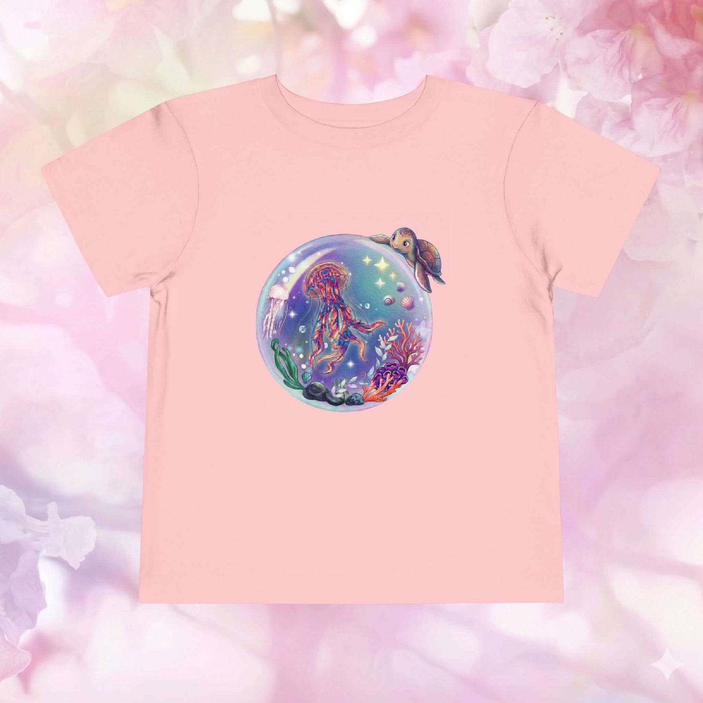 Toddler jellyfish t-shirt featuring a magical underwater bubble with jellyfish and colorful coral on a pink background.