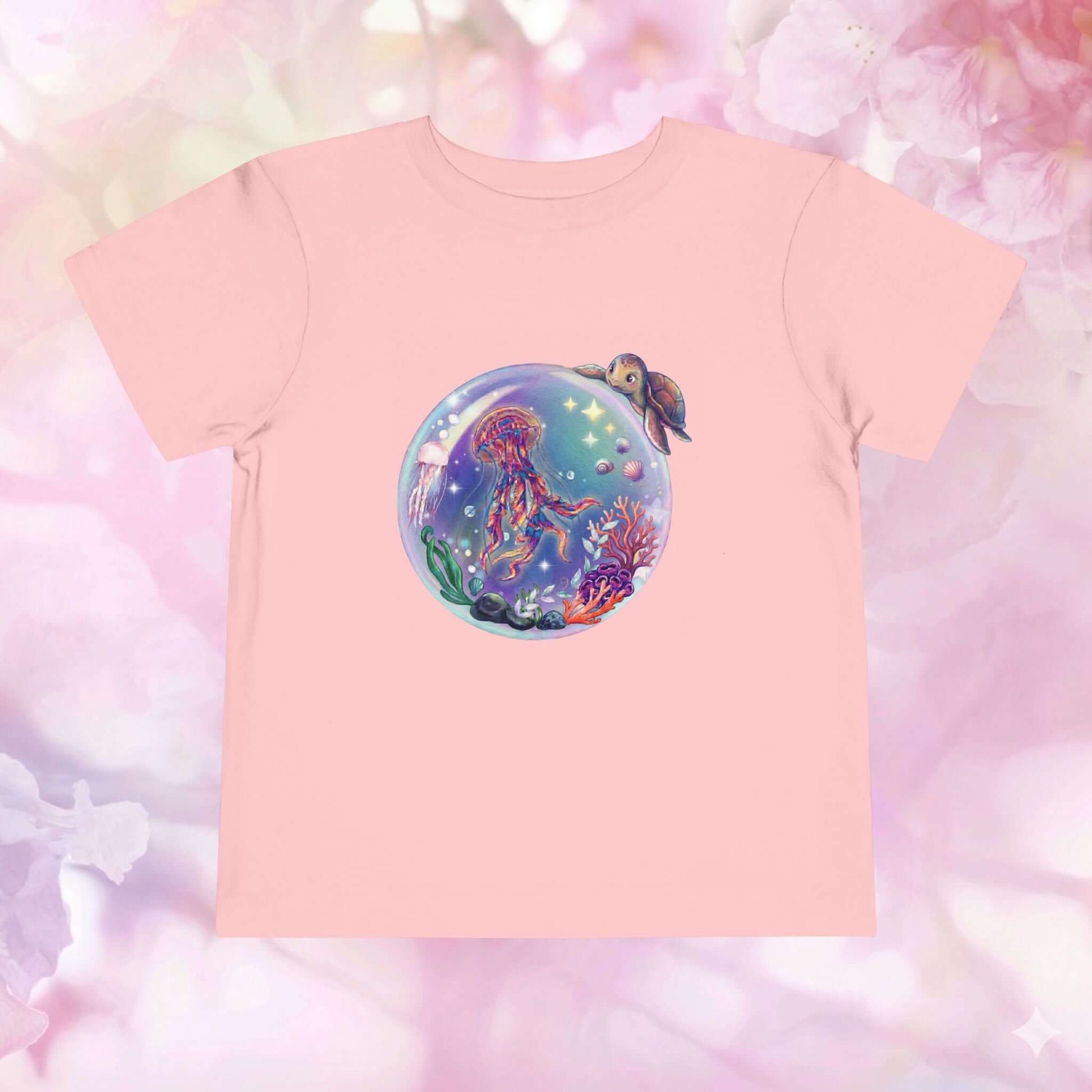 Toddler jellyfish t-shirt featuring a magical underwater bubble with jellyfish and colorful coral on a pink background.