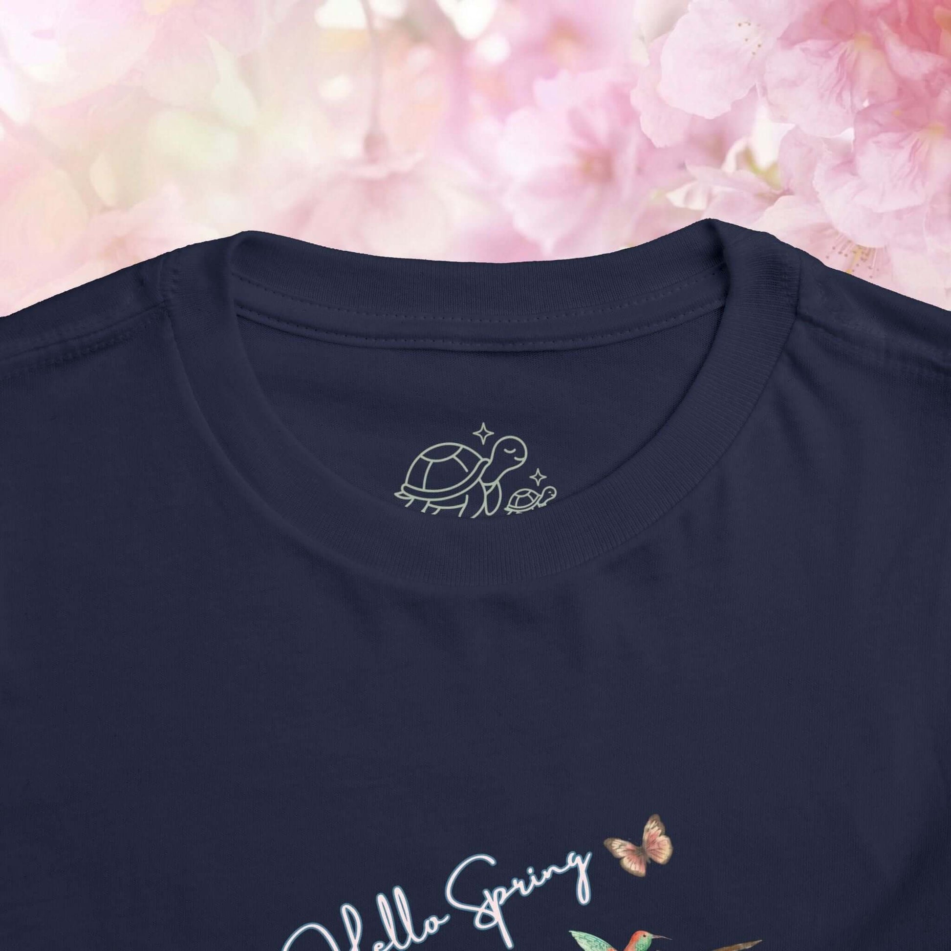 Toddler spring shirt featuring a turtle design on a navy background with floral details.