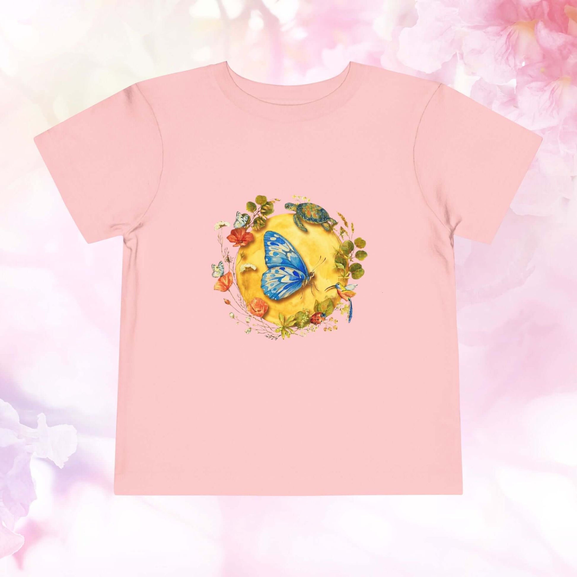 Radiant Blue Butterfly Toddler T-Shirt featuring a colorful butterfly and floral design on a pink background.