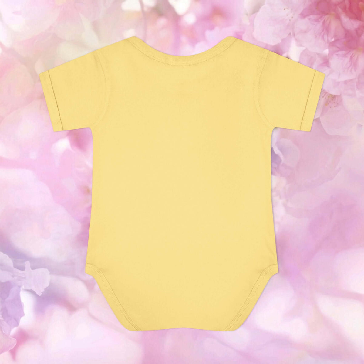 Back view of the Autumn Bounty Infant Bodysuit in yellow against a pink floral background.