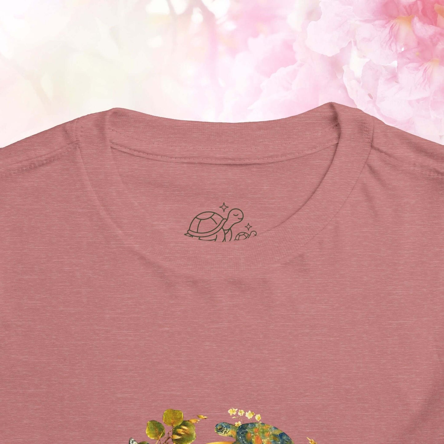 Close-up of the Radiant Blue Butterfly Toddler T-Shirt featuring a turtle design on the neck area.