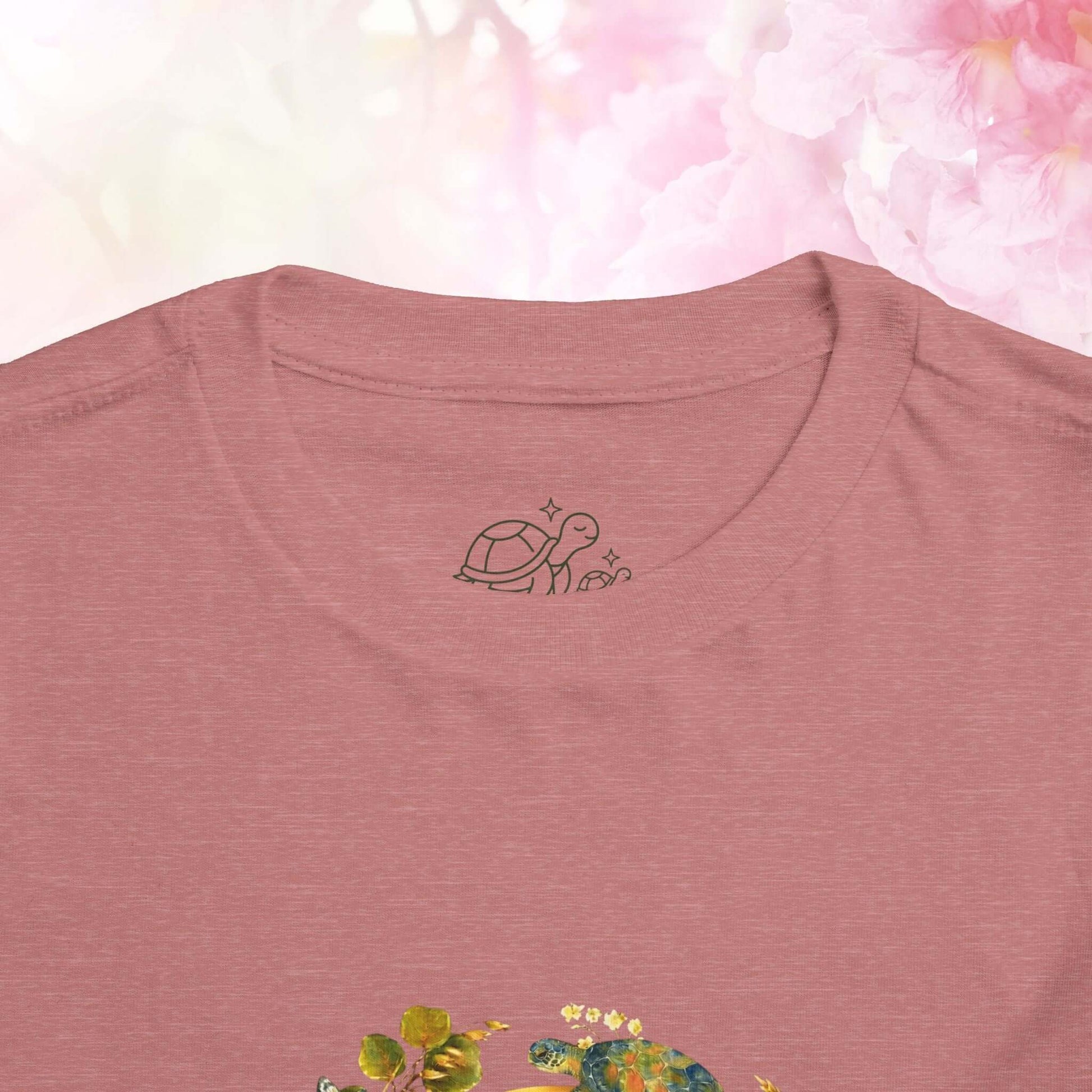 Close-up of the Radiant Blue Butterfly Toddler T-Shirt featuring a turtle design on the neck area.