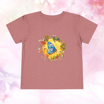 Radiant Blue Butterfly Toddler T-Shirt featuring a blue butterfly on a sunny design with flowers and a turtle.