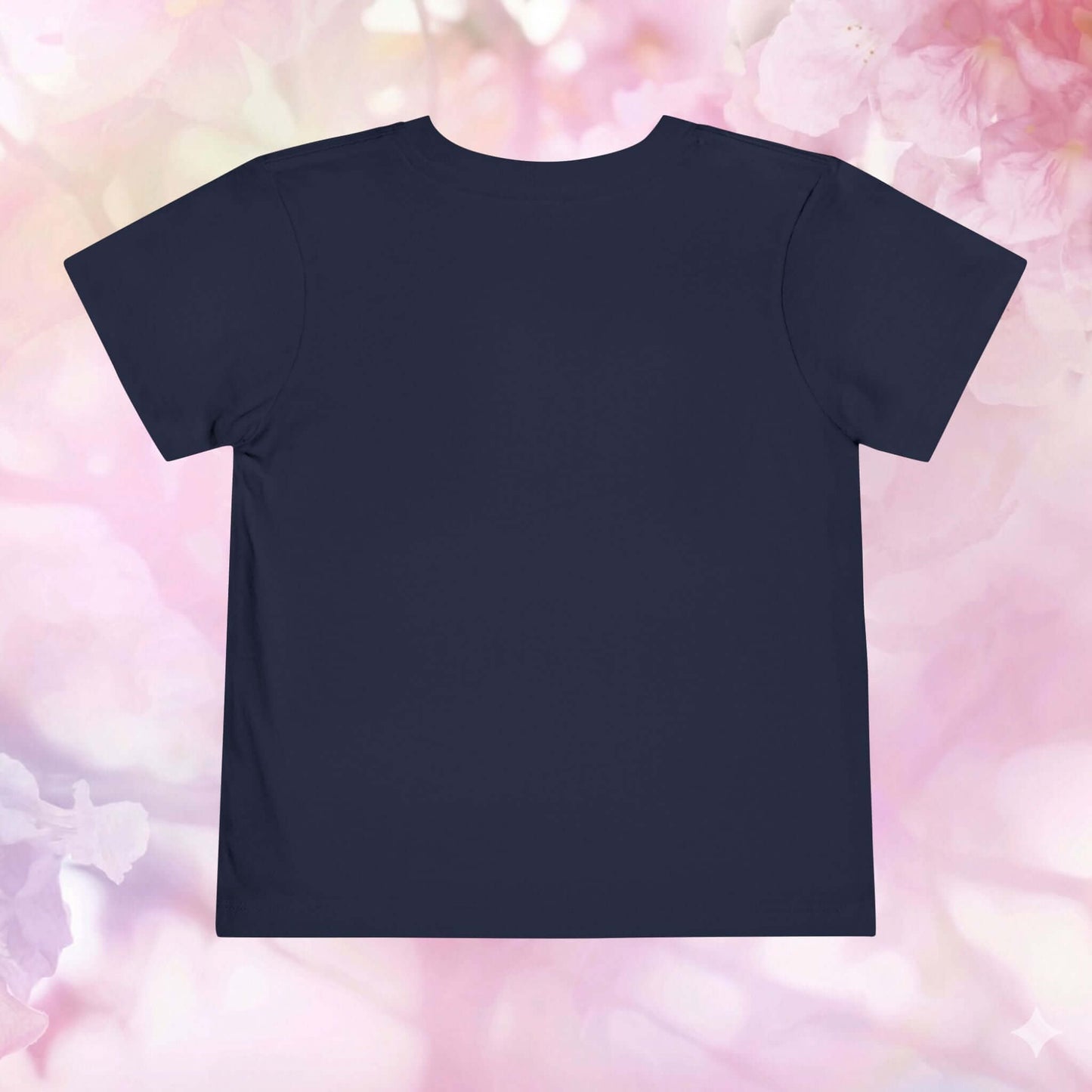 Back view of a toddler spring shirt against a soft floral background, perfect for welcoming spring.