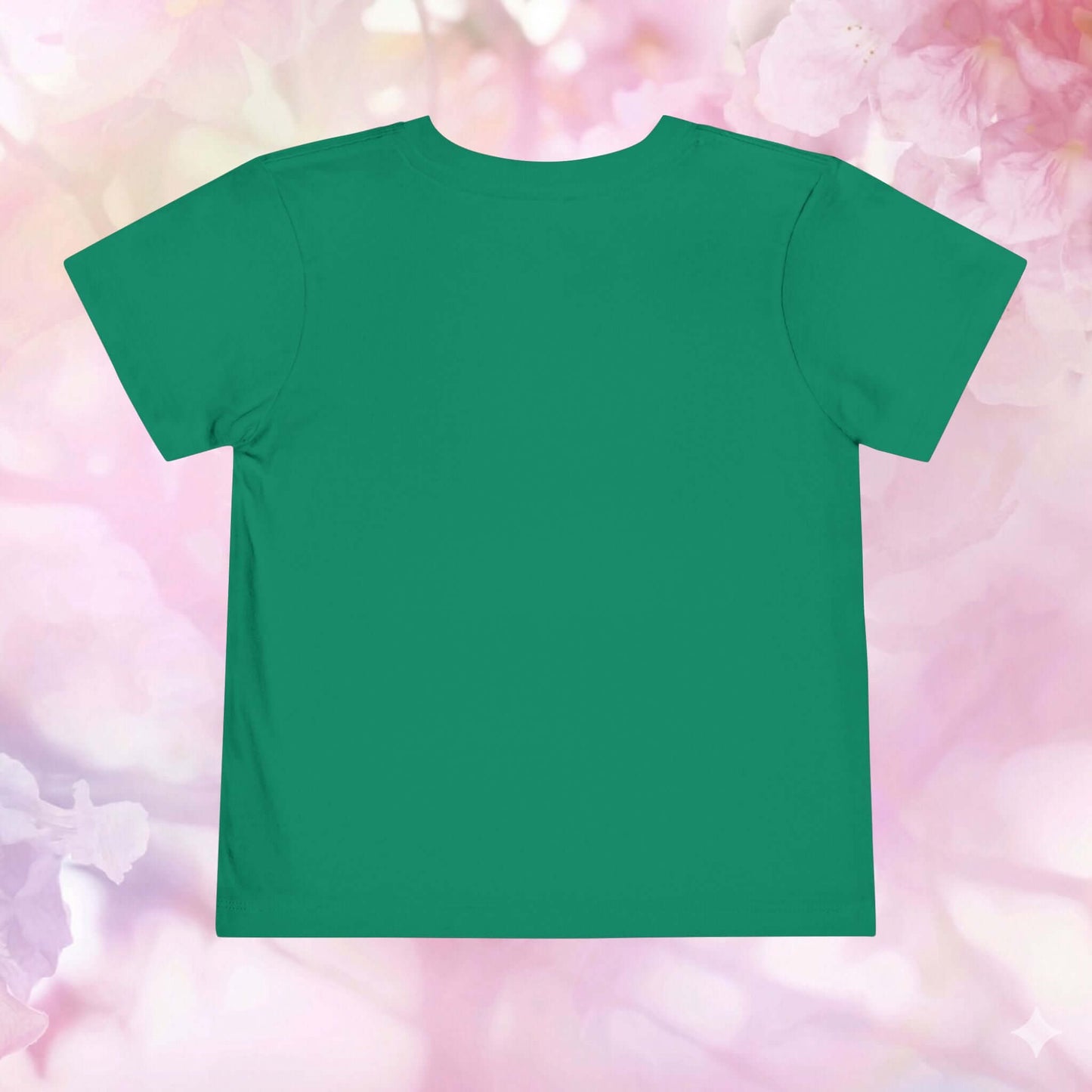 Back view of a green toddler jellyfish t-shirt on a pastel floral background, perfect for little ocean lovers.